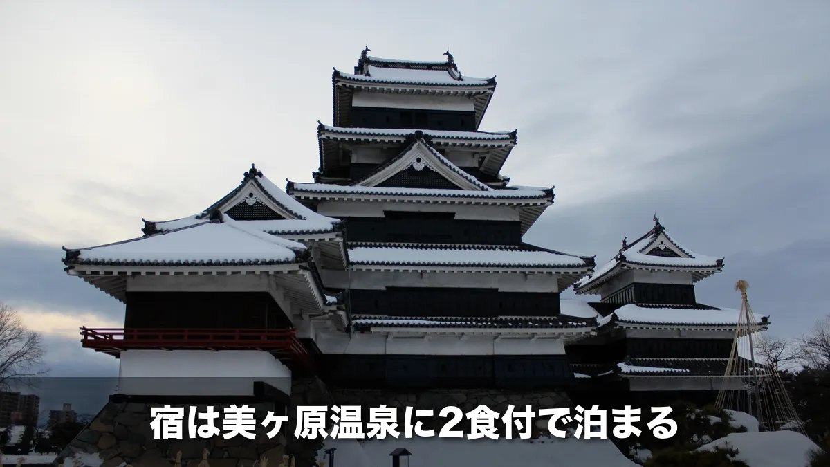 屋根に雪が積もった松本城の天守