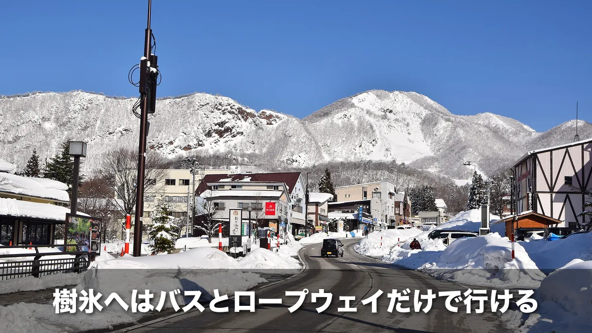 雪の積もった冬の蔵王温泉街と山なみ