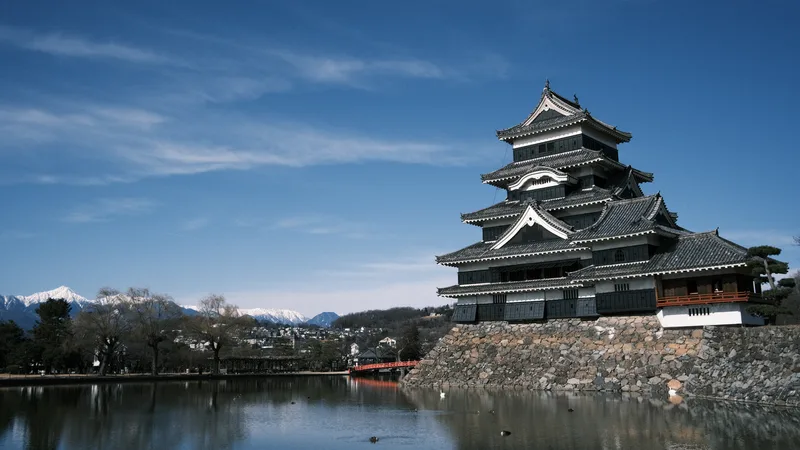 青空と雪の北アルプスを背にした冬の松本城